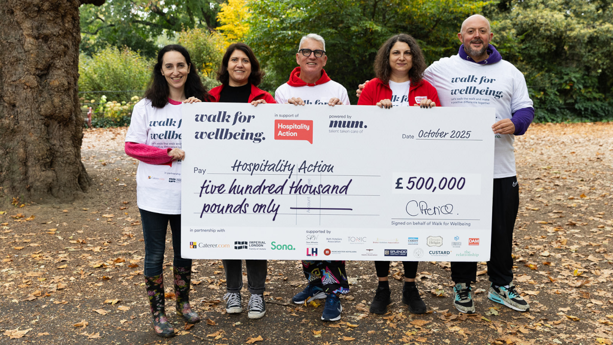 walk for wellbeing holding a large cheque in the woods post